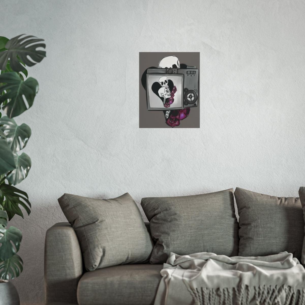 Gray sofa with decorative cushions and a plant in a room with a wall art piece.